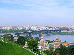 grey concrete bridge leading to city during daytime HD wallpaper