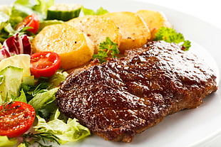 steak with potato and salad on white ceramic plate