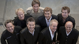 several men wearing a black suit smiling