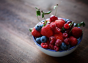 selective focus photo of raspberries, strawberries, and grapes on bowl
