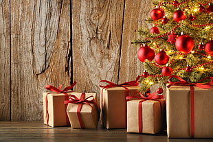 five brown gift box beside Christmas tree