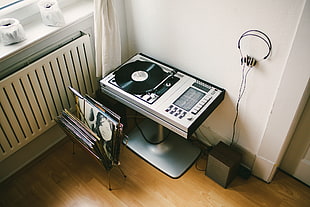rectangular black and white turntable with vinyl record rack inside room