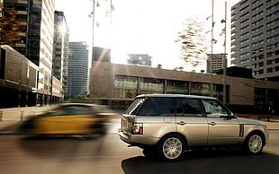silver SUV on road near grey concrete building during daytime HD wallpaper