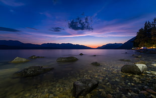 timelapse photography of body of water near mountain during golden hour HD wallpaper