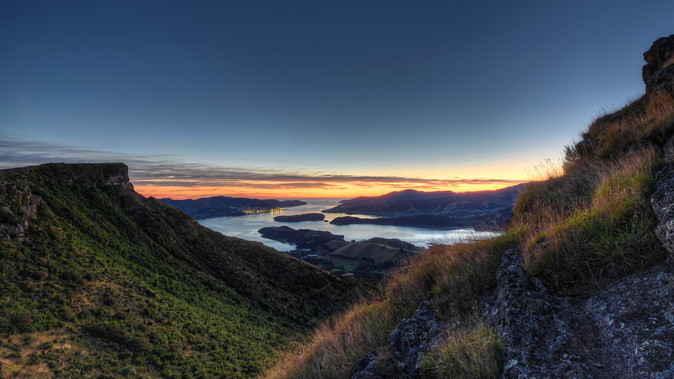 mountain range near body of water during sunset HD wallpaper