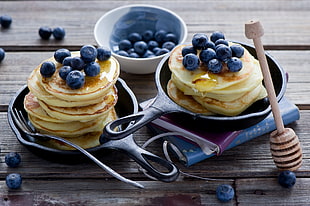 two black steel frying pans with blue berry pancakes