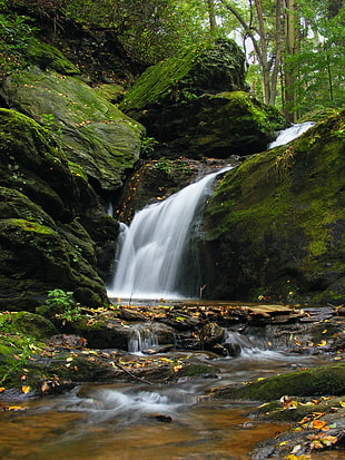 waterfalls between green rocks