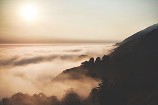 aerial photography of mountain cliff and fogs