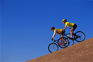 two person riding in black mountain bikes HD wallpaper