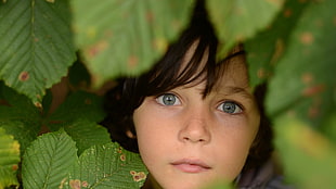 closeup photo of girl surrounded by leaves