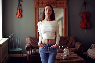 woman wearing white off-shoulder top and blue jeans