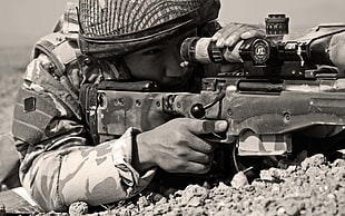 gray scale photo of soldier holding AWM sniper rifle