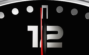 black and gray clock pointing at 12 o'clock