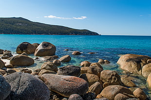 panoramic photo of stones in blue ocean under the blue sky during day time HD wallpaper