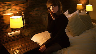 woman sitting on bed with lamp on