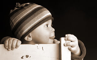 sepia photograph of toddler with knit hat