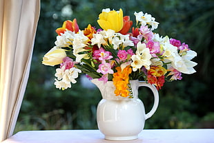 assorted color petaled flower with white ceramic vase