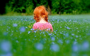 girl wearing red shirt at the middle of purple petaled flower farm