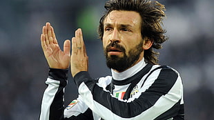 man wearing black and white striped long-sleeve shirt clapping hand