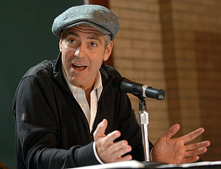selective focus of man in black jacket talking in front of microphone