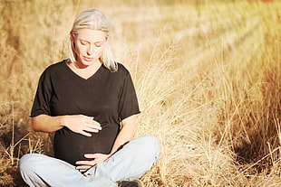 pregnant woman sitting on brown grass during daytime HD wallpaper