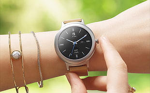 round silver-colored, black face analog watch with brown strap