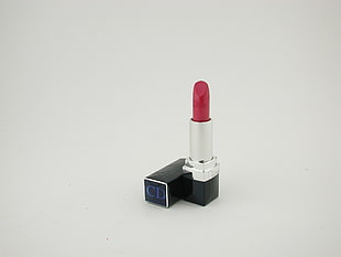 red CD lipstick on white surface