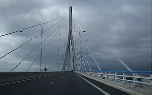 white and gray bridge under dark clouds