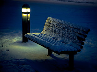 snow on brown wooden bench