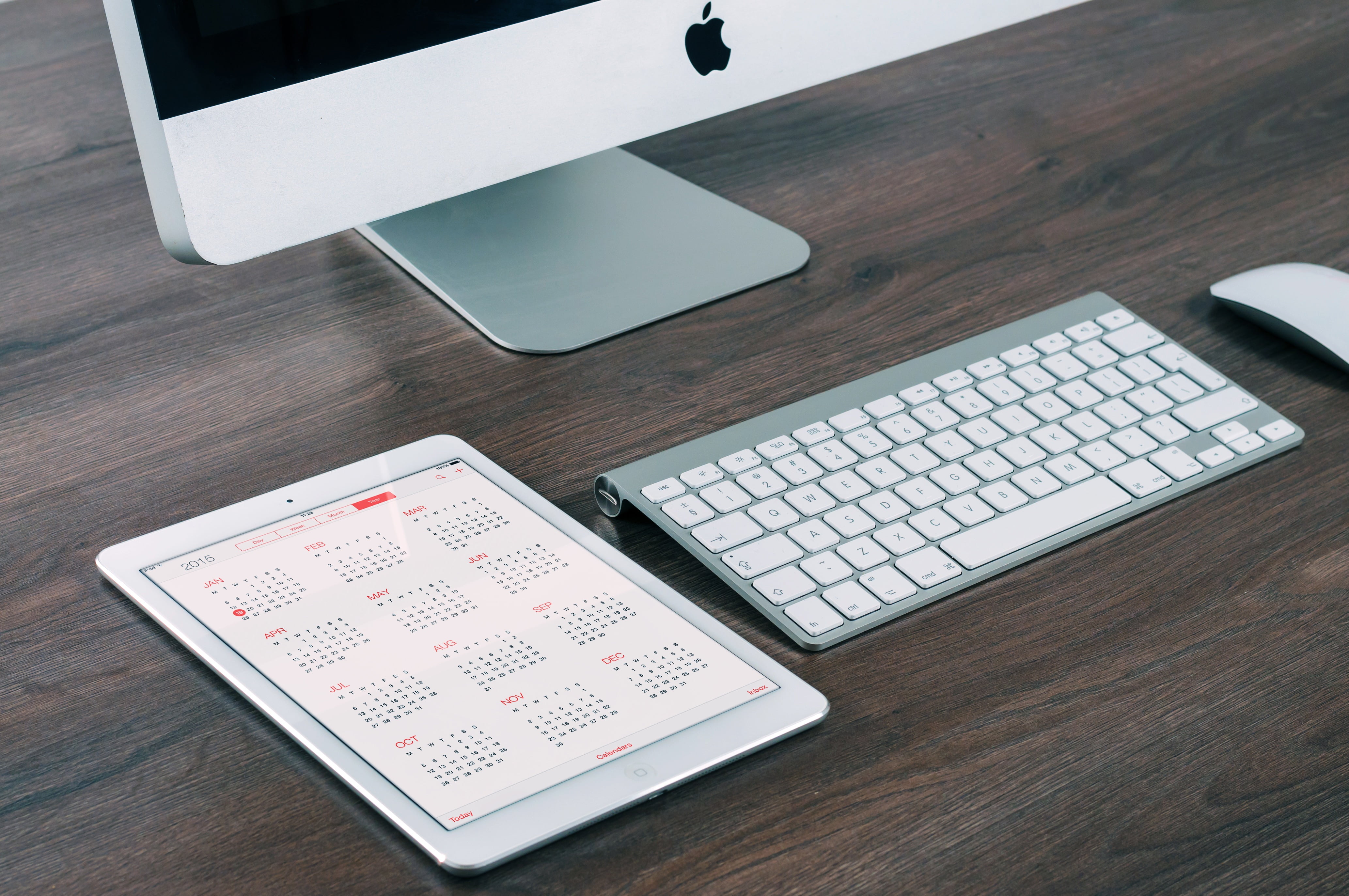 closeup photo of Apple wireless keyboard and mighty mouse on brown surface