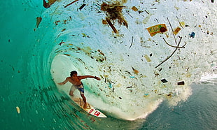 man on surfboard, surfing, trash, blue, tropical water