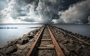 brown metal train rail, clouds, railway, sea
