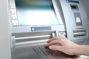 person using gray ATM