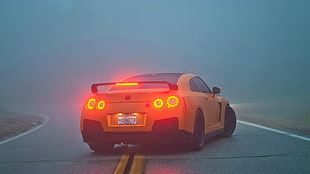 yellow NISSAN GT-R R35 on road during foggy weather condition