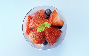 sliced Strawberries and blueberry on clear glass container