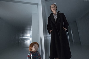 Chuckie Doll beside woman in black coat