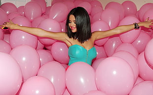 woman wearing teal strapless blouse with pink balloons