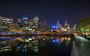 body of water near buildings during night time HD wallpaper