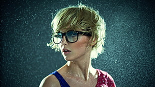 blonde woman wearing black framed sunglasses and blue tank top