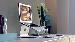 photo of turned on MacBook Air with stand near Magic keyboard and Magic Mouse