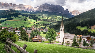 white cathedral near houses with landscape background, alta badia, italy HD wallpaper