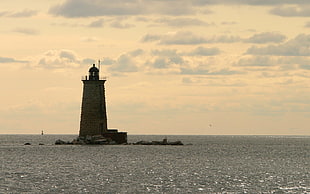 photo of lighthouse on sea HD wallpaper