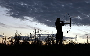 silhouette of man holding bow