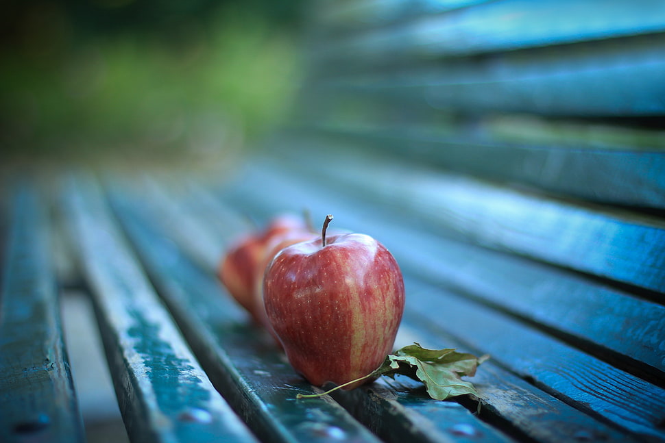 two red apples on top of black metal bench HD wallpaper