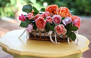 pink and purple Rose flowers in wicker basket on table