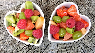 slice fruits on white heart shape ceramic bowl