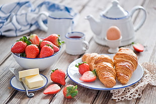 baked pastry with strawberries on ceramic bowl and plate