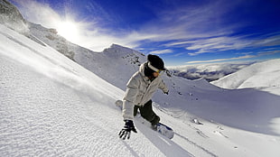 man in white bobble jacket snowboarding
