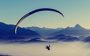 person on parachute with mountain background