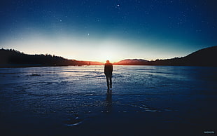 silhouette of man standing on shore during golden hour photo, people, ice, sky, stars